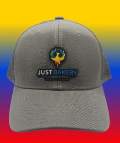 Gray baseball cap featuring an embroidered 'JUST BAKERY' logo with a colorful flame emblem; rainbow gradient background